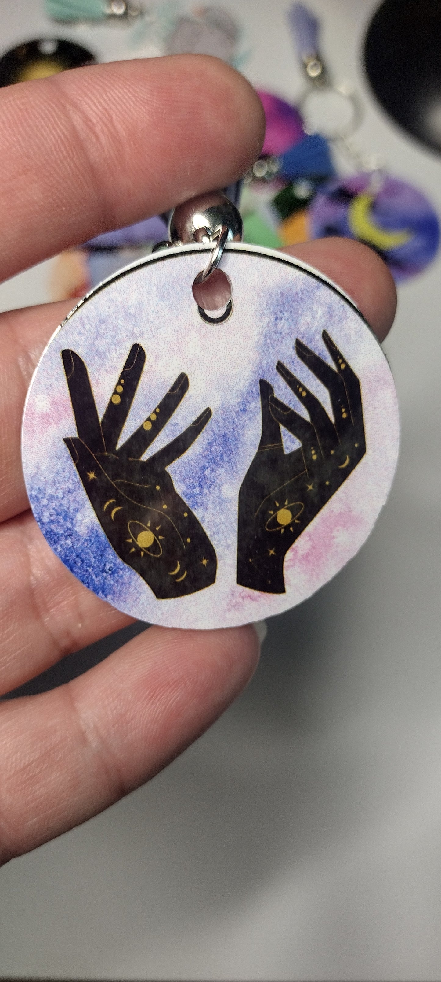key chain of outstreatched hands, imperfect with black line on top